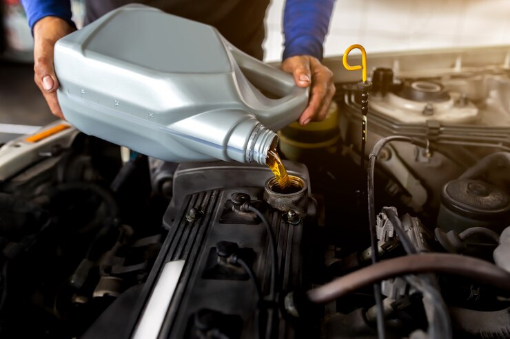 car-mechanic-replacing-pouring-fresh-oil-into-engine-maintenance-repair-service-station_39420-274